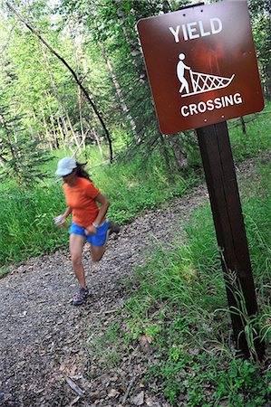 sled (transportation) - Female jogger runs past a dog sled crossing sign on the Far North Bicentennial Park Trail in Anchorage, Southcentral Alaska, Summer Stock Photo - Rights-Managed, Code: 854-03739620