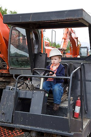 funny images of people driving - Toddler boy wearing a hard hat sits in the driver's seat of a steam roller at a construction site in Anchorage, Southcentral Alaska, Summer Stock Photo - Rights-Managed, Code: 854-03740015