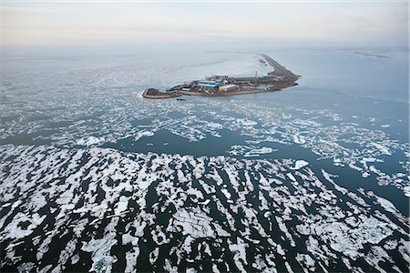 Aerial view of an oil well drilling platform on a man-made island and surrounded by broken sea ice, Prudhoe Bay, Beaufort Sea near Deadhorse, Arctic Alaska, Summer Stock Photo - Rights-Managed, Code: 854-03740260