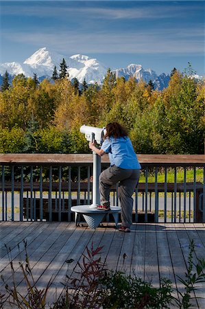 Woman visitor looks through telescope at the southside view of Mt. Mckinley and Alaska Range from the Alaska Veterans Memorial rest area along George Parks Highway, Denali State Park, Southcentral Alaska, Autumn Stock Photo - Rights-Managed, Code: 854-03844969