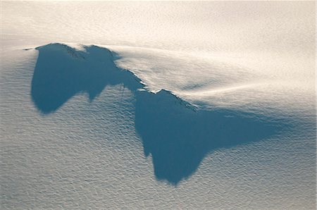 Long shadows cast from a nunatak and radio tower on the Harding Ice Field in Kenai Fjords National Park, Southcentral Alaska, Winter Stock Photo - Rights-Managed, Code: 854-03846054