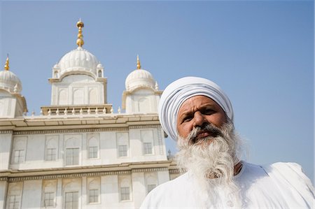 sikh - Low angle view of a man with Gurudwara in the background, Sikh Temple, Gwalior, Madhya Pradesh, India Stock Photo - Rights-Managed, Code: 857-03192704