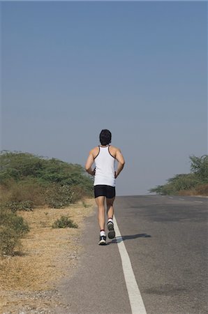 simsearch:633-01715682,k - Rear view of a man jogging at the roadside Stock Photo - Rights-Managed, Code: 857-03554032