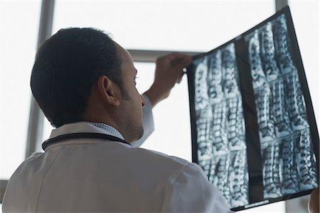 Doctor examining an x-ray report, Gurgaon, Haryana, India Stock Photo - Rights-Managed, Code: 857-03554180