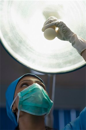 Female surgeon adjusting a surgical lamp, Gurgaon, Haryana, India Stock Photo - Rights-Managed, Code: 857-03554239