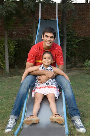 family shoes - Man playing with his daughter on a slide, New Delhi, India Stock Photo - Rights-Managed, Code: 857-03553796