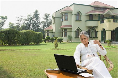 Woman working on a laptop in a lawn, New Delhi, India Stock Photo - Rights-Managed, Code: 857-03553851