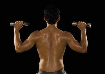 Rear view of a man exercising with dumbbells Stock Photo - Rights-Managed, Code: 857-03553895