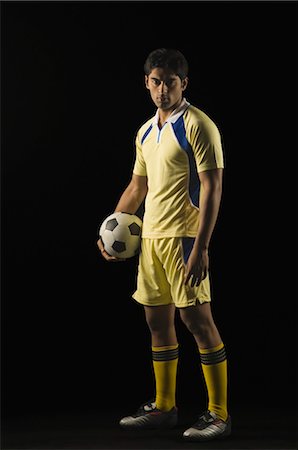 soccer player holding ball - Portrait of a man holding a soccer ball Stock Photo - Rights-Managed, Code: 857-03553942