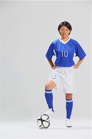 soccer player - Woman In Soccer Uniform Posing With Ball Foto de stock - Con derechos protegidos, Código: 858-06617813
