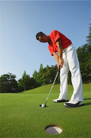 ethnic golf - Golfer Putting Into Hole Stock Photo - Rights-Managed, Code: 858-06756167