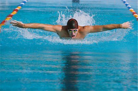 simsearch:858-06756400,k - Swimmer Doing The Butterfly Stroke In Pool Stock Photo - Rights-Managed, Code: 858-06756420