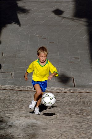 Young Boy Playing Soccer in the Street Stock Photo - Rights-Managed, Code: 858-03046604