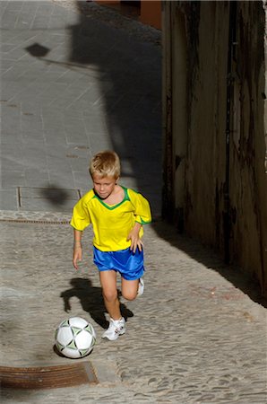 Young Boy Playing Soccer in the Street Stock Photo - Rights-Managed, Code: 858-03046602