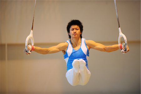 Young man balancing on gymnast rings Stock Photo - Rights-Managed, Code: 858-03047715