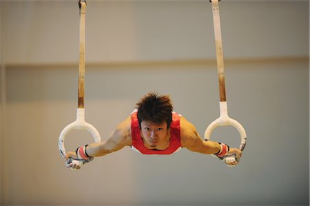 Young man balancing on gymnast rings Stock Photo - Rights-Managed, Code: 858-03047716