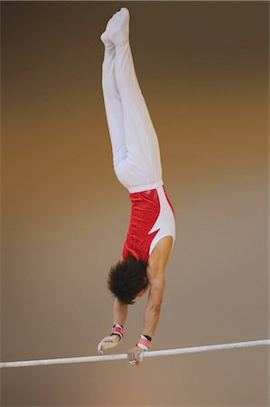 simsearch:858-03047740,k - Gymnast dangling on uneven parallel bars Stock Photo - Rights-Managed, Code: 858-03047730