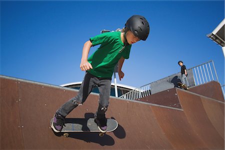 determined youth sports - Boy skateboarding in skate park Foto de stock - Con derechos protegidos, Código: 858-03049275