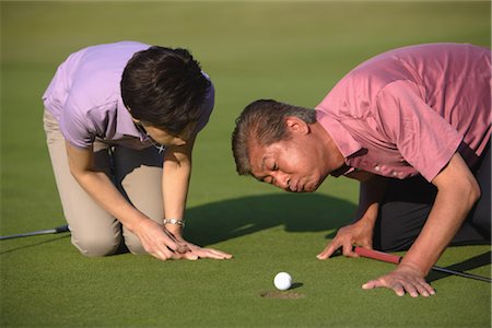 putt - Couple blowing on a golf ball Stock Photo - Rights-Managed, Code: 858-03049953