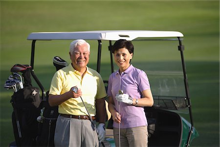 simsearch:858-03050428,k - Couple standing by the golf cart while holding golf clubs Stock Photo - Rights-Managed, Code: 858-03049960