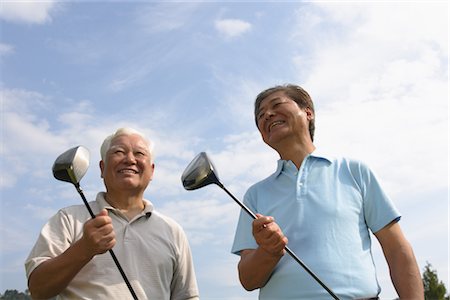 simsearch:858-03050428,k - Low angle view of smiling golfers holding golf clubs Stock Photo - Rights-Managed, Code: 858-03049963