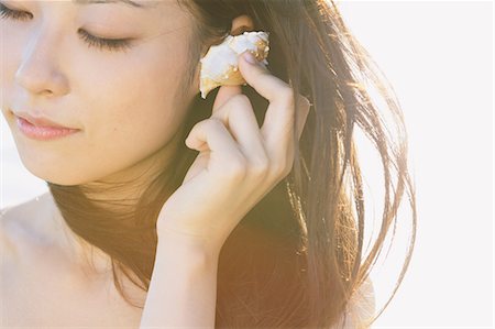 simsearch:859-06405000,k - Portrait of a Japanese woman listening to a sea shell with closed eyes Stock Photo - Rights-Managed, Code: 859-06404889