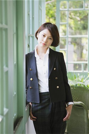 Femme japonaise dans un permanent veste noire de la fenêtre Photographie de stock - Rights-Managed, Code: 859-06404937