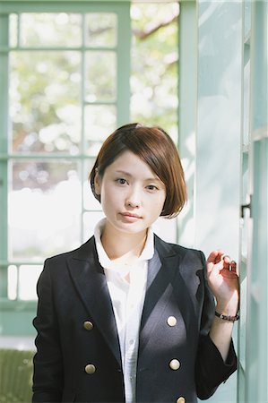 Femme japonaise dans un permanent veste noire de la fenêtre Photographie de stock - Rights-Managed, Code: 859-06404930
