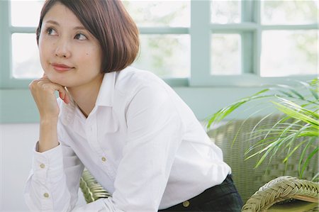 single woman sitting on a chair home - Japanese woman in a white shirt sitting and looking away Stock Photo - Rights-Managed, Code: 859-06404941