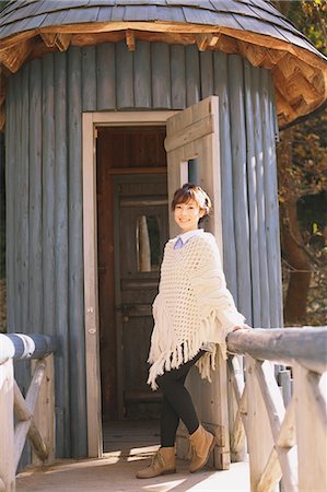 poncho - Japanese woman in a white cardigan leaning against a wooden door Stock Photo - Rights-Managed, Code: 859-06404976