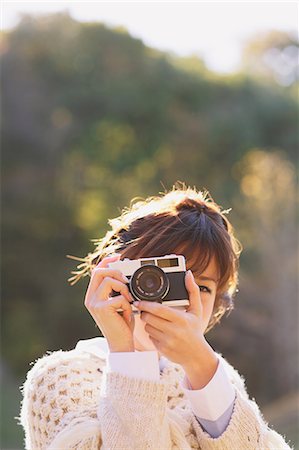 Portrait of a Japanese woman in a white cardigan taking pictures with an old camera Stock Photo - Rights-Managed, Code: 859-06404979