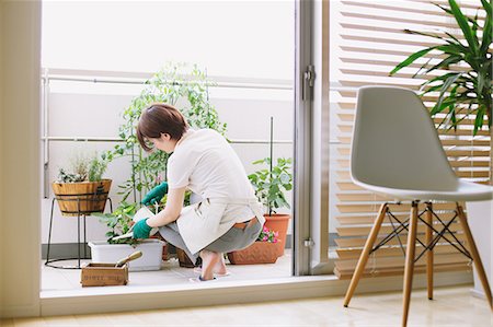 pot light - Mid adult woman gardening on the balcony Stock Photo - Rights-Managed, Code: 859-06469737