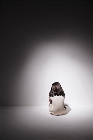 Sad girl in a white dress sitting on the floor against the wall Stock Photo - Rights-Managed, Code: 859-06537704