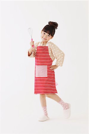 Young girl with apron smiling at camera Stock Photo - Rights-Managed, Code: 859-06537986
