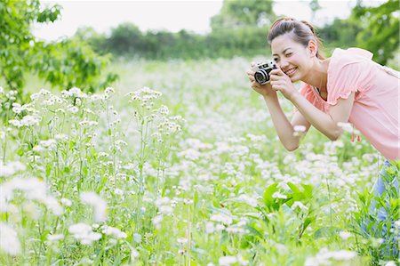 Japanese woman taking pictures in a meadow Stock Photo - Rights-Managed, Code: 859-06710948
