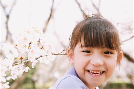 Young girl smiling at camera with cherry blossoms Stock Photo - Rights-Managed, Code: 859-06808397