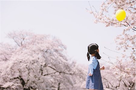simsearch:862-03712492,k - Young girl with balloon and cherry trees in the background Stock Photo - Rights-Managed, Code: 859-06808406