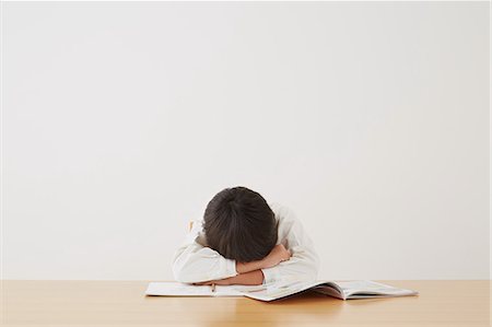 Young boy asleep on his textbook on wooden desk Stock Photo - Rights-Managed, Code: 859-07710988