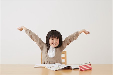 Young girl doing her homework on wooden desk Stock Photo - Rights-Managed, Code: 859-07710996