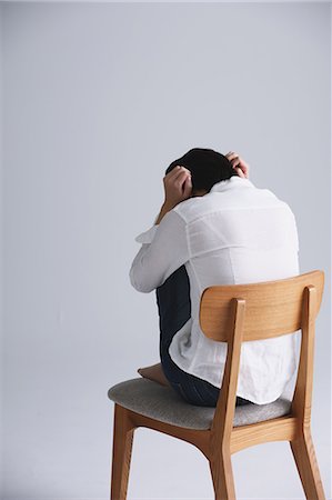 depression on white background - Desperate Japanese young woman in a white shirt sitting on a chair Stock Photo - Rights-Managed, Code: 859-07711133