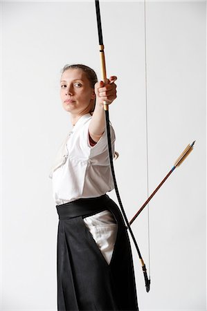 Caucasian woman practicing traditional Kyudo Japanese archery on white background Stock Photo - Rights-Managed, Code: 859-09018732