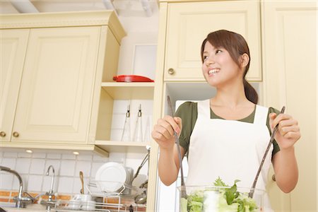 Front view of a woman tossing salad in kitchen Stock Photo - Rights-Managed, Code: 859-03038452