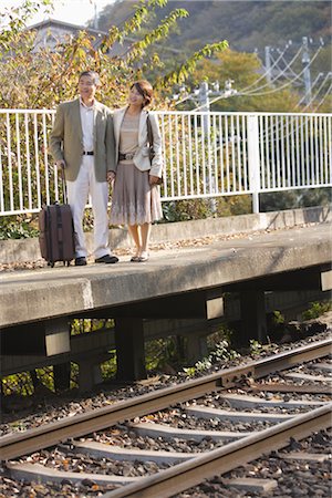 Couple waiting for train while standing on platform Stock Photo - Rights-Managed, Code: 859-03038579