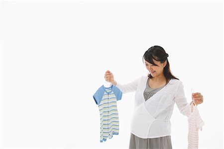 Enceinte femme Holding cintres des vêtements de bébé Photographie de stock - Rights-Managed, Code: 859-03600067