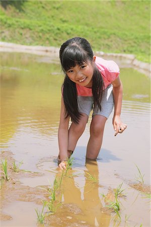 Girl Planting Seed At Wetland Foto de stock - Con derechos protegidos, Código: 859-03755216