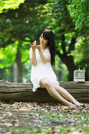 Young Woman Sitting with Bird  in her Hands Stock Photo - Rights-Managed, Code: 859-03782193