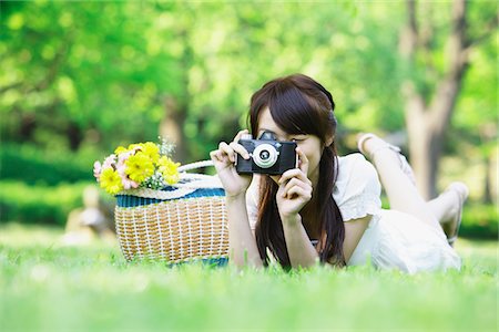 Young Woman Lying on Grass and Taking Photographs Stock Photo - Rights-Managed, Code: 859-03782243