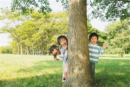 Enfants se cachent derrière le tronc d'arbre Photographie de stock - Rights-Managed, Code: 859-03805798