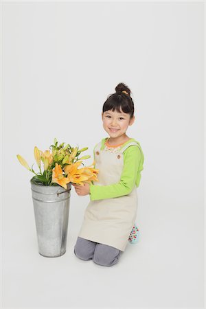 Girl Kneeling With Bucket Full Of Flowers Stock Photo - Rights-Managed, Code: 859-03806074