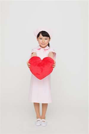 Girl Dressed As Nurse Holding Heart Stock Photo - Rights-Managed, Code: 859-03806087